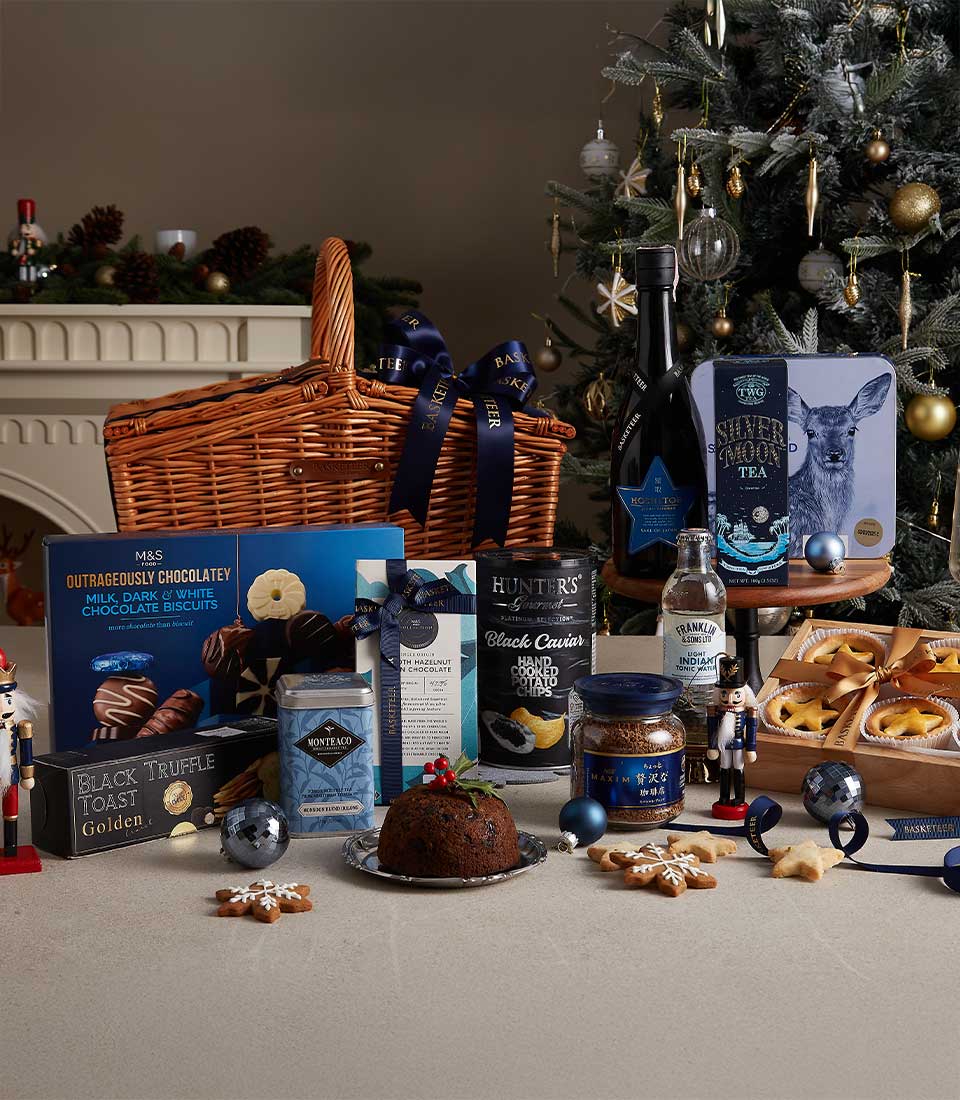 Luxury midnight Christmas hamper with red wine, gourmet chocolates, tea, and festive treats in wicker basket