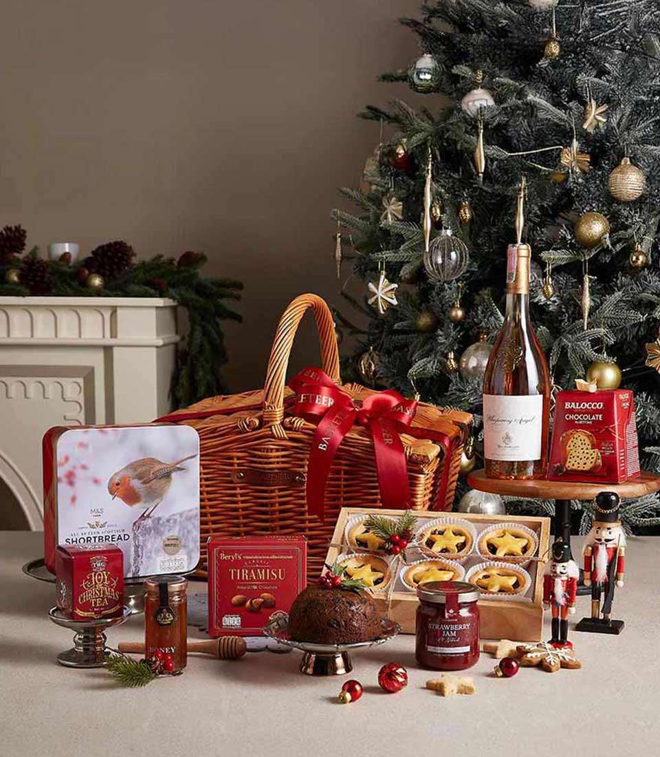 Festive Christmas wine hamper with wicker basket, holiday treats, shortbread, tea, chocolates, and festive nutcracker
