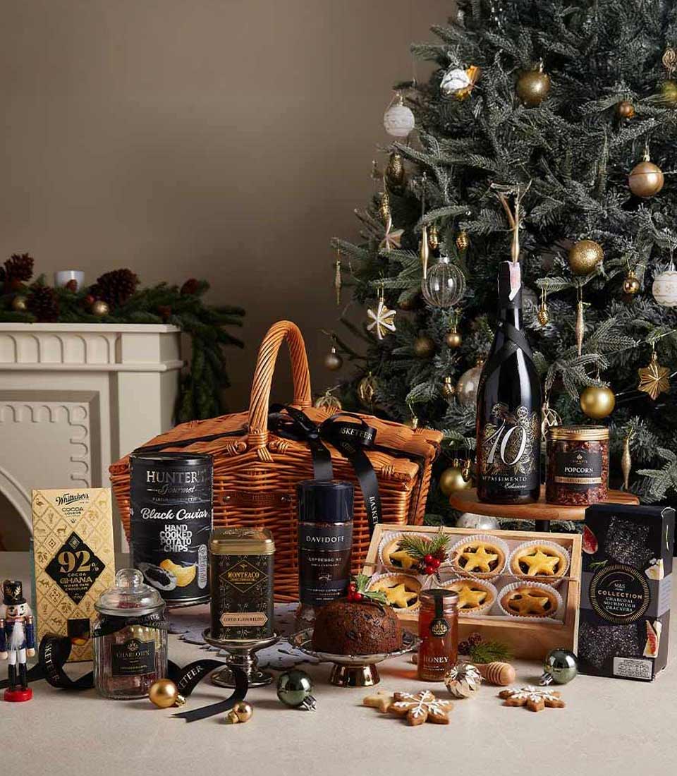 Premium Christmas hamper with red wine, gourmet chocolates, caviar chips, and artisan crackers in wicker basket