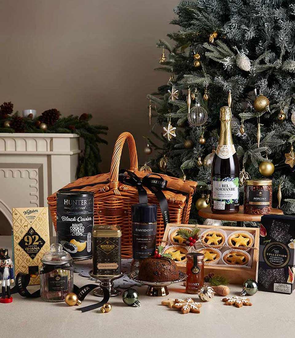 Luxury Christmas hamper with gourmet chocolates, caviar crisps, espresso, and festive treats in woven wicker basket