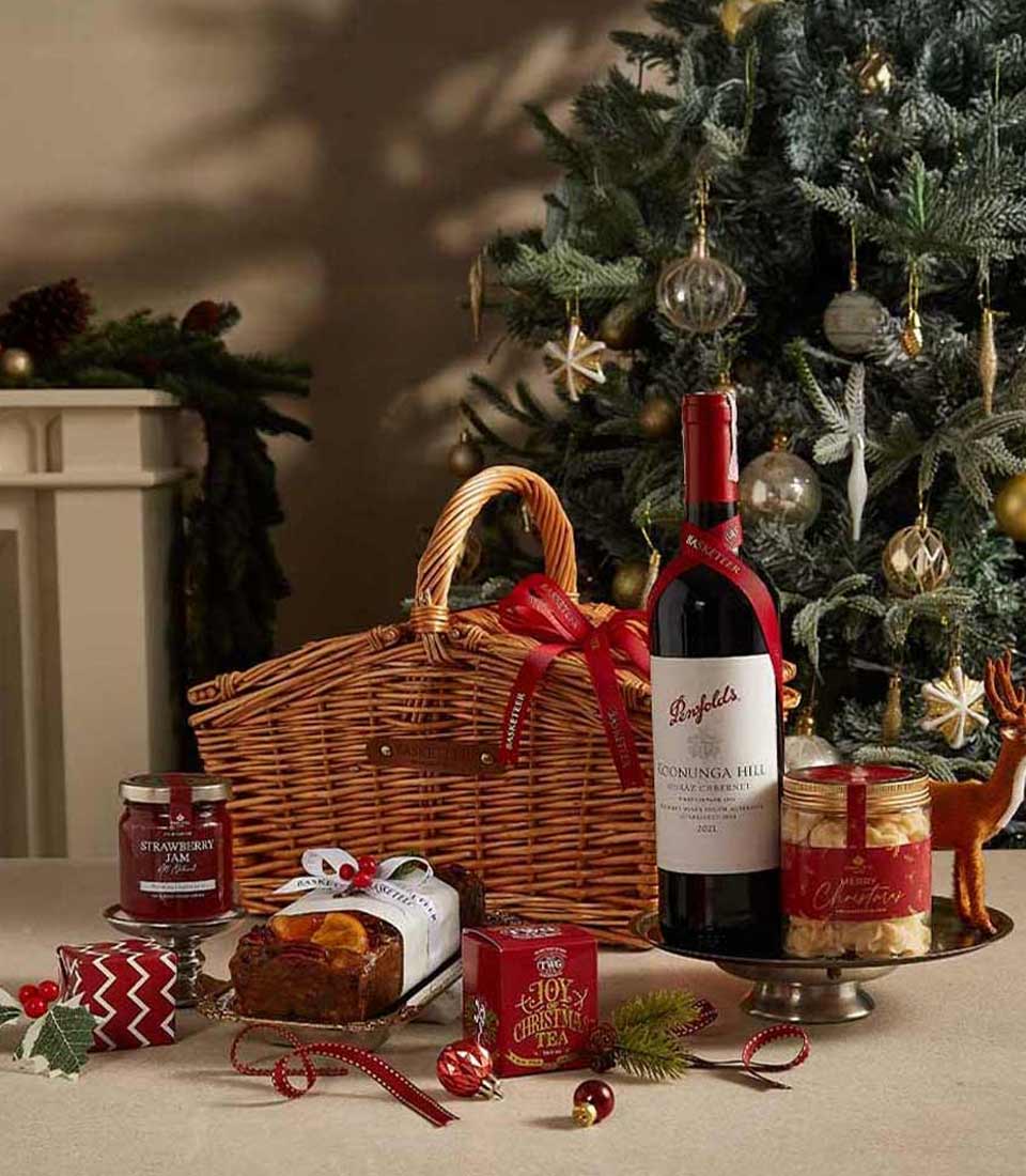 Festive Indulgence Christmas hamper with Penfolds red wine, artisan preserves, fruit cake, and gourmet treats in woven basket