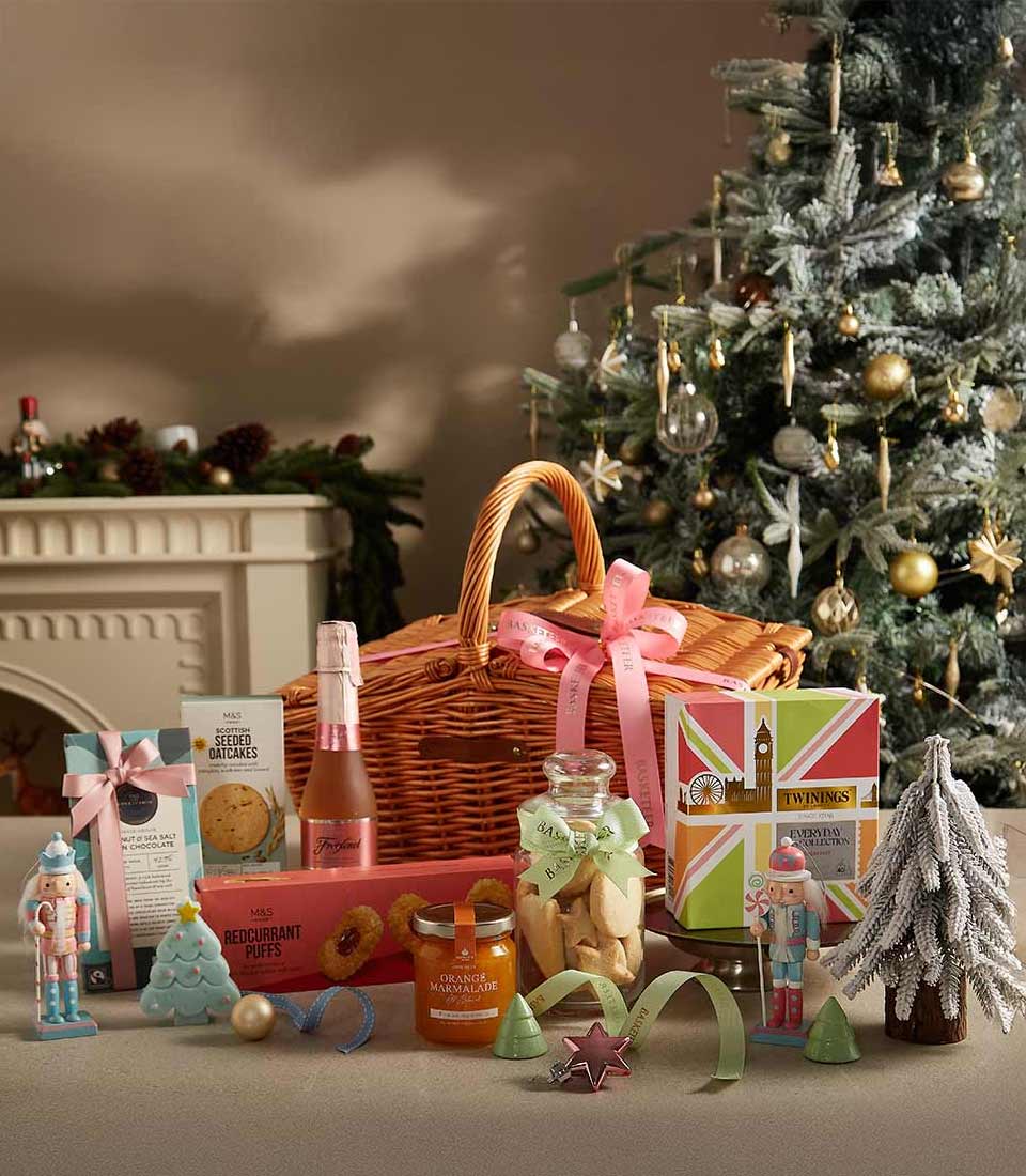 Wicker picnic basket with champagne, Scottish oatcakes, marmalade, cookies, and festive Christmas decorations