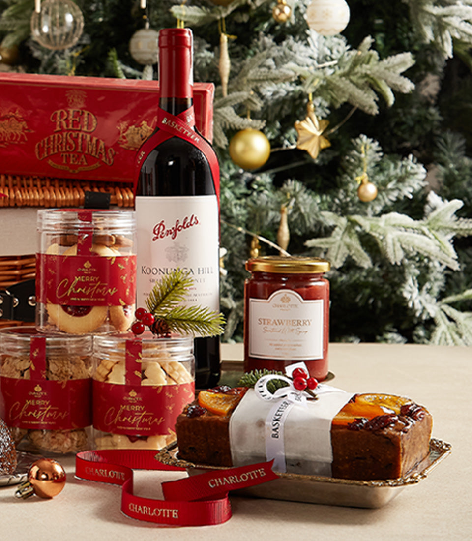 Festive red wine Christmas hamper with artisan cookies, strawberry preserve, and fruitcake on silver tray