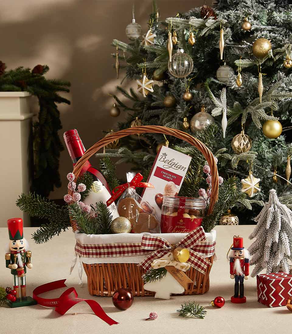 Festive wicker Christmas gift basket with red wine, Belgian chocolates, gingerbread, and preserves tied with red checkered