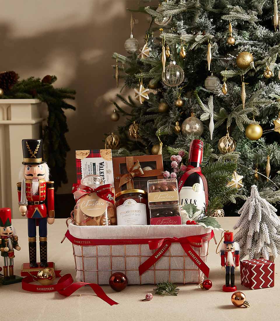 Elegant Christmas gift basket with red wine, strawberry preserve, chocolates, cookies, and shortbread, dressed in red ribbon