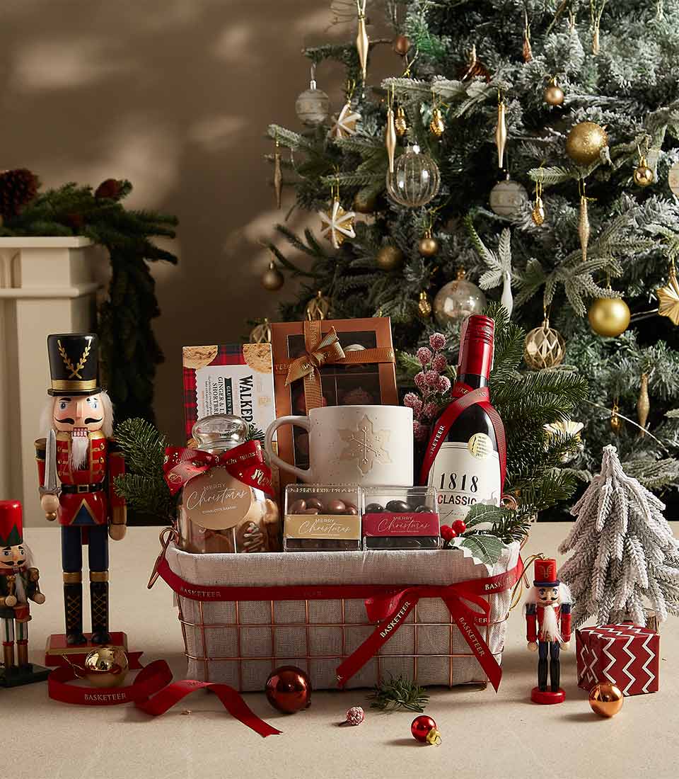 Festive Christmas gift basket with red wine, snowflake mug, shortbread, and chocolate treats
