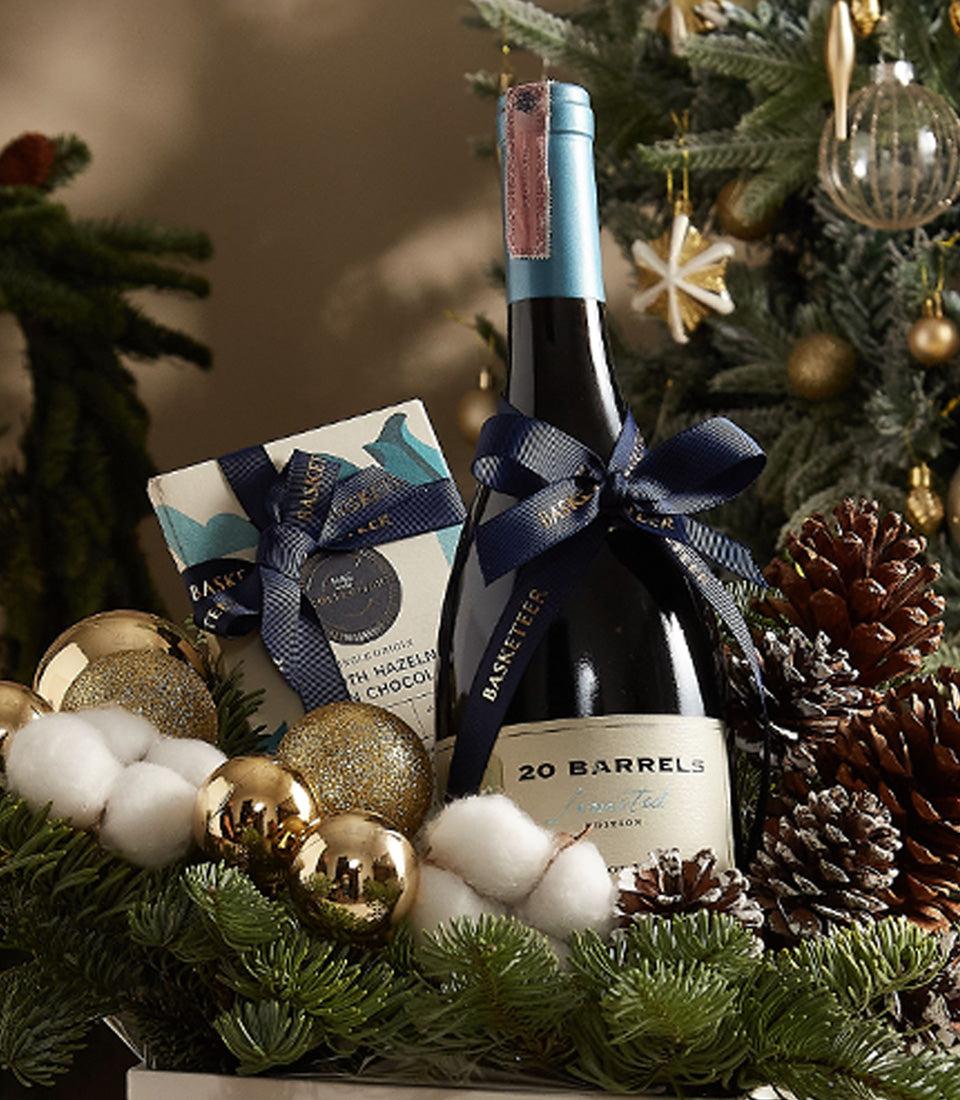 Deluxe Christmas pine gift box with red wine, artisan chocolates, and festive gold ornaments