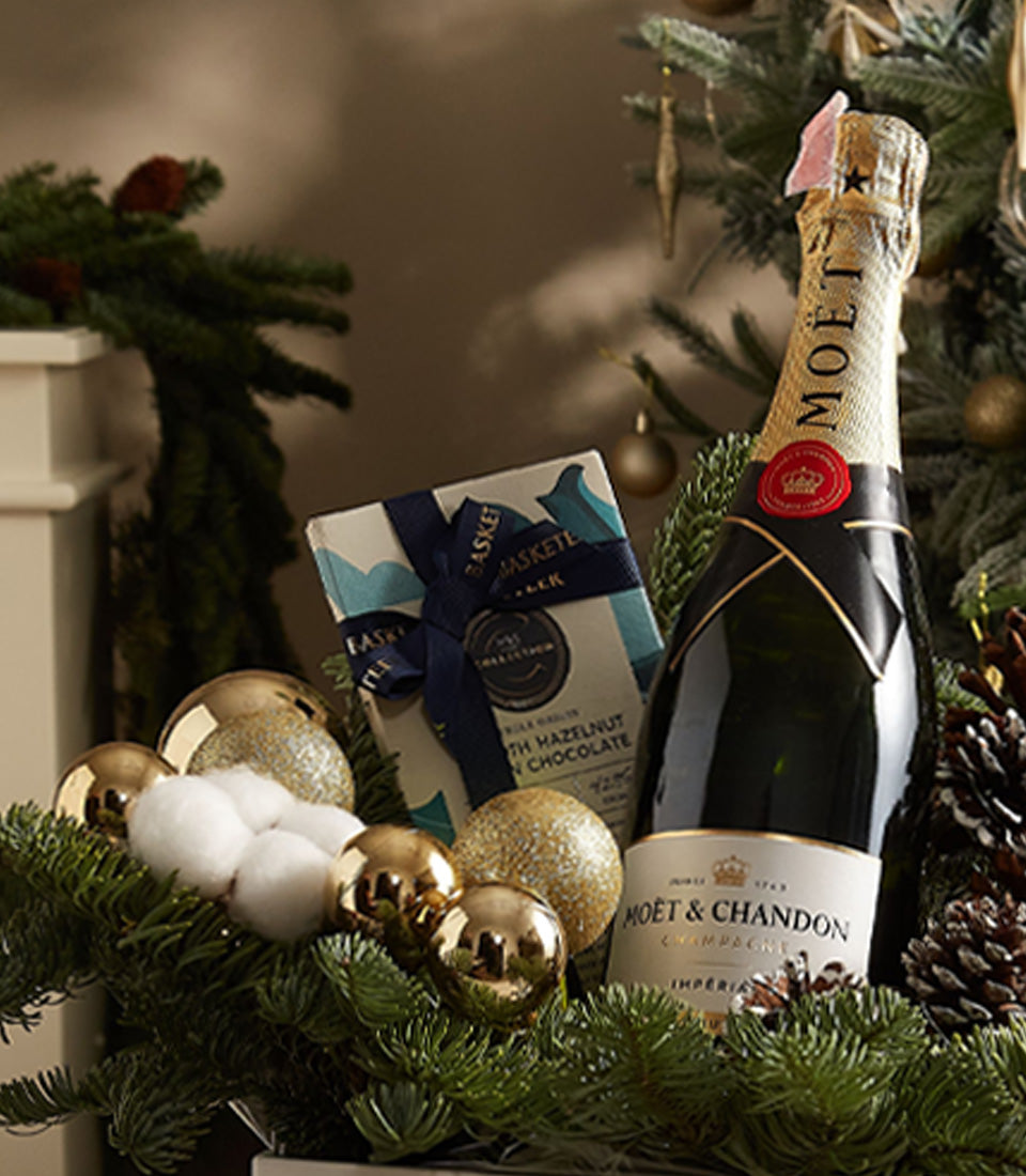 Luxury champagne and artisan chocolate gift box with gold ornaments and evergreen, perfect for Christmas celebrations
