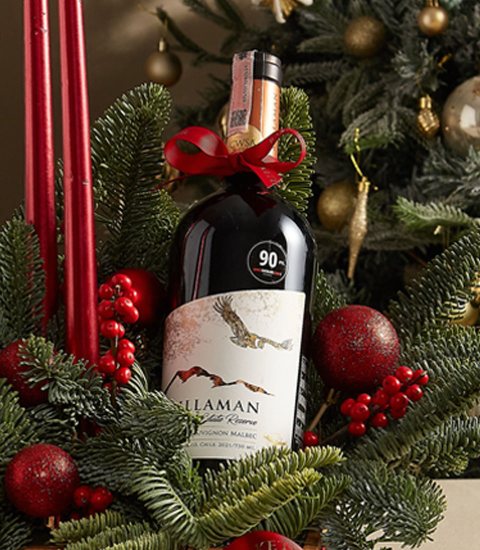 Festive Elegance Centerpiece Box with premium red wine, red ornaments, pine branches, and holiday candles