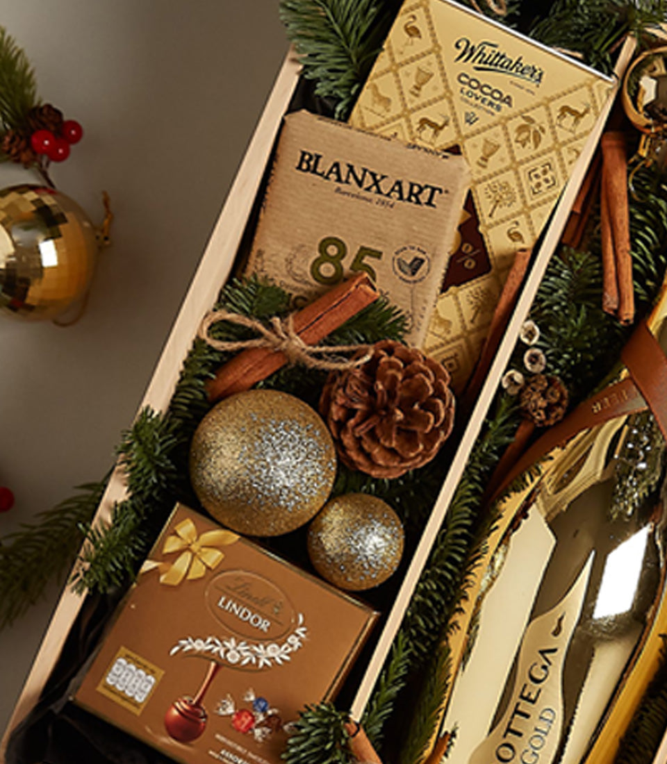 Golden Luxe Holiday Gift Tray with Bottega Gold, luxury chocolates, and festive pine branches for Christmas