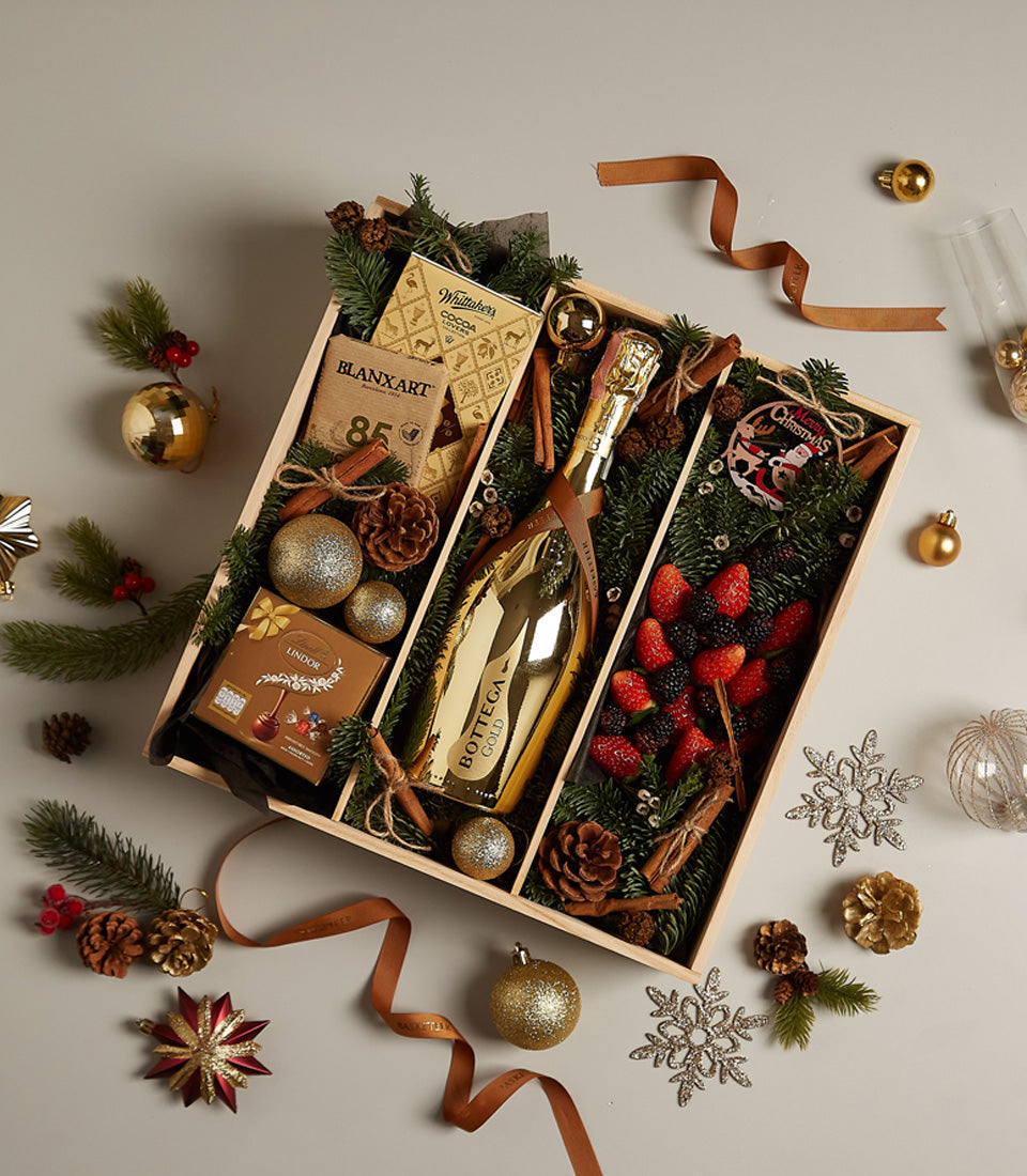 Golden luxury Christmas gift tray with Bottega Gold sparkling wine, Belgian chocolates, fresh berries, and festive pine