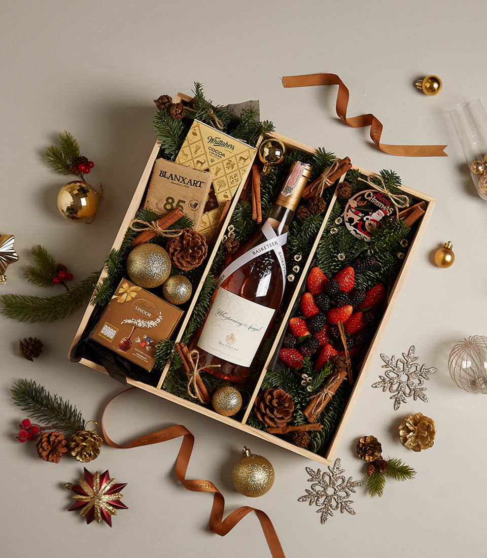 Elegant wooden Christmas gift box with Whispering Angel rosé wine, artisan chocolates, fresh berries, and festive gold