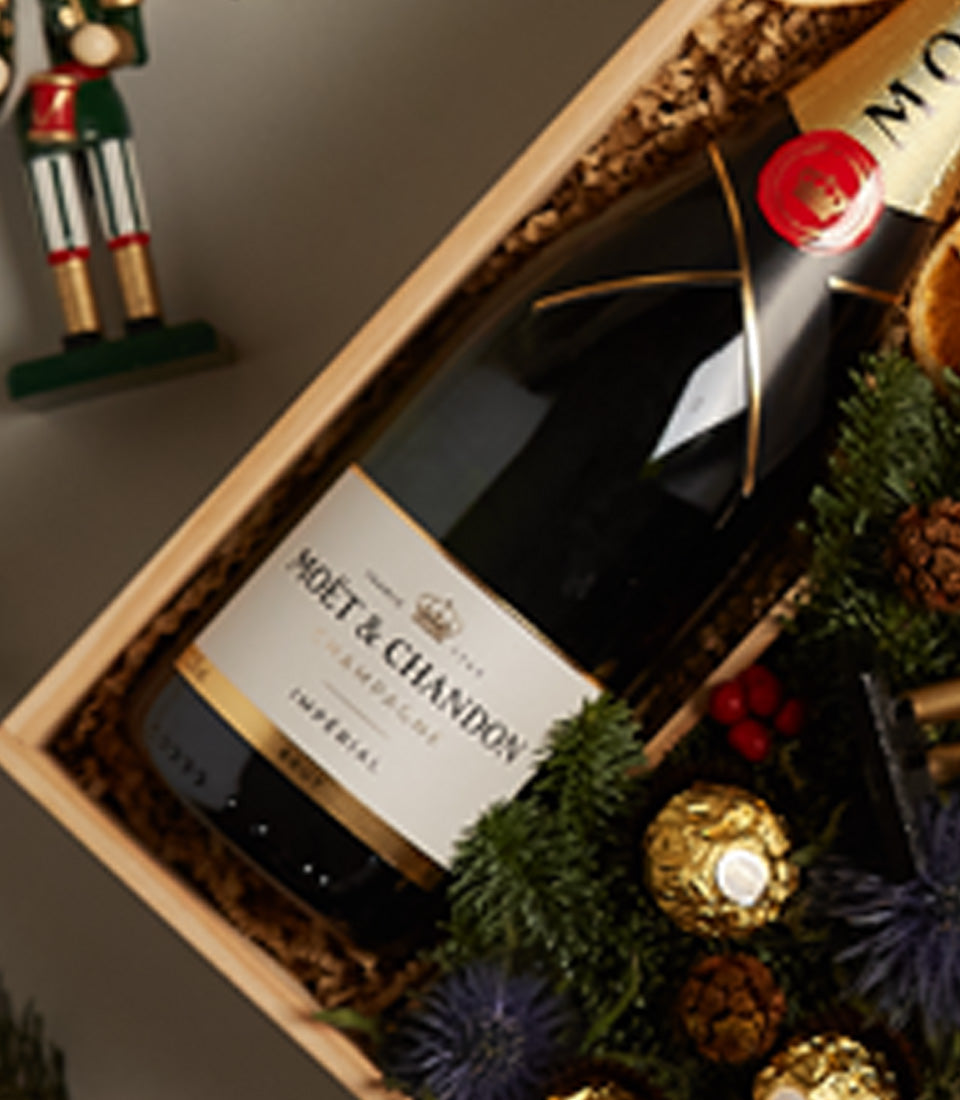 Moët & Chandon champagne gift box with nutcracker, gold chocolates, and festive greenery for Christmas