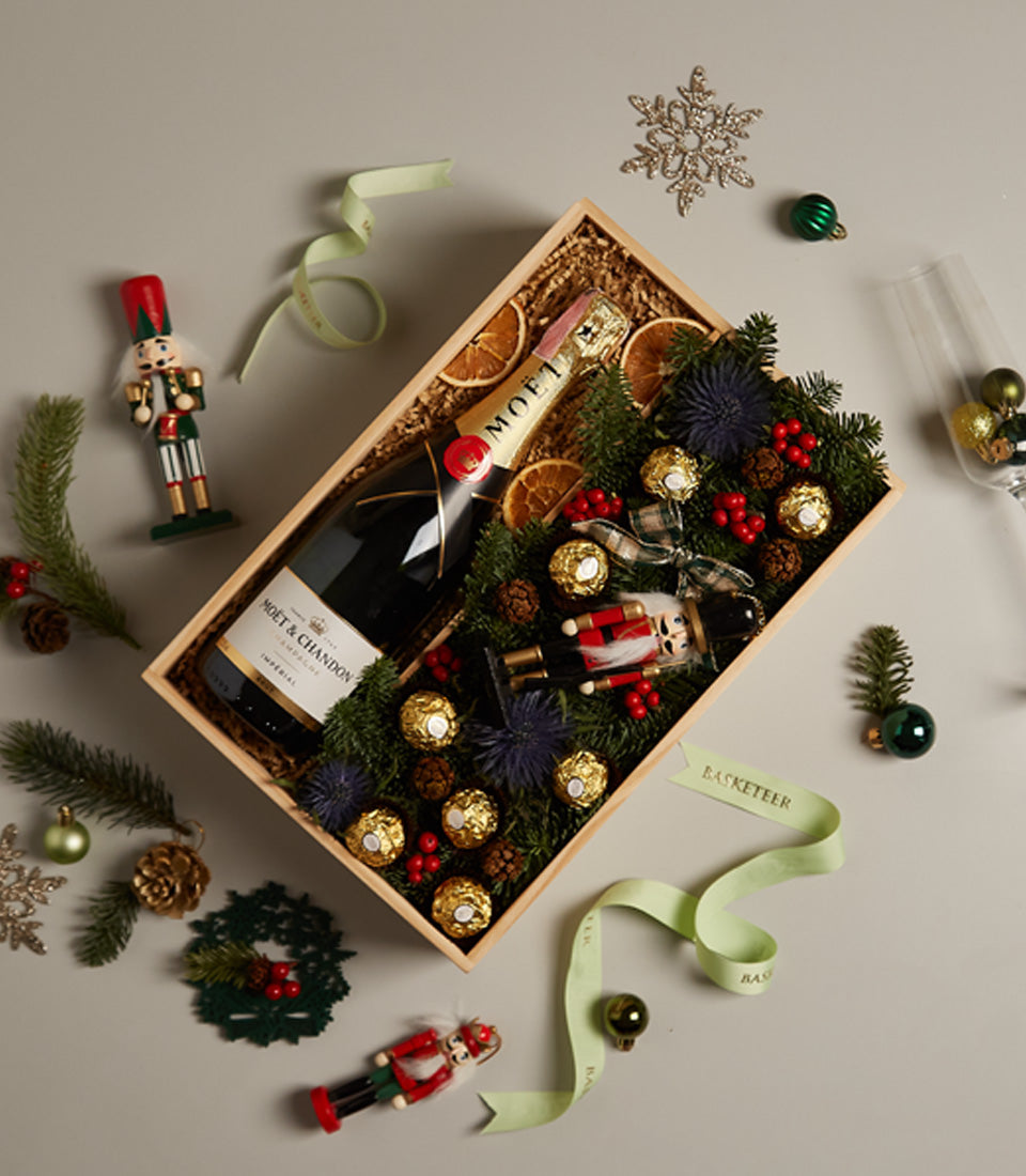 Festive champagne gift box with Moët & Chandon, Ferrero Rocher, pinecones, and nutcracker ornament
