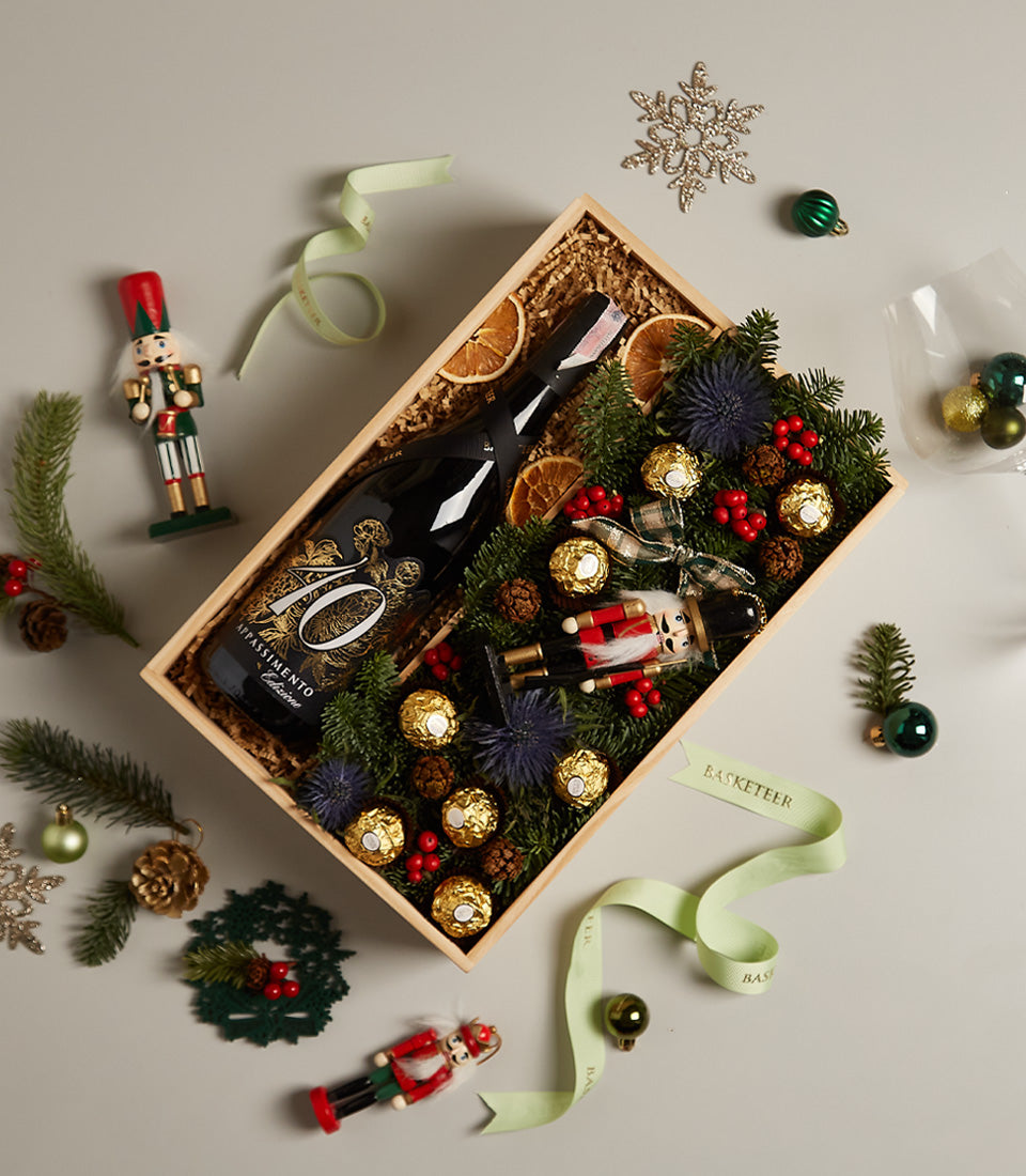 Premium red wine gift box with nutcracker, Ferrero Rocher, dried citrus, and festive Christmas decorations