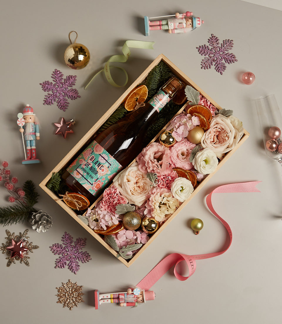 Rosy Celebration Floral Gift Box with Blanc de Noir sparkling wine, pink roses, dried citrus, and gold Christmas baubles