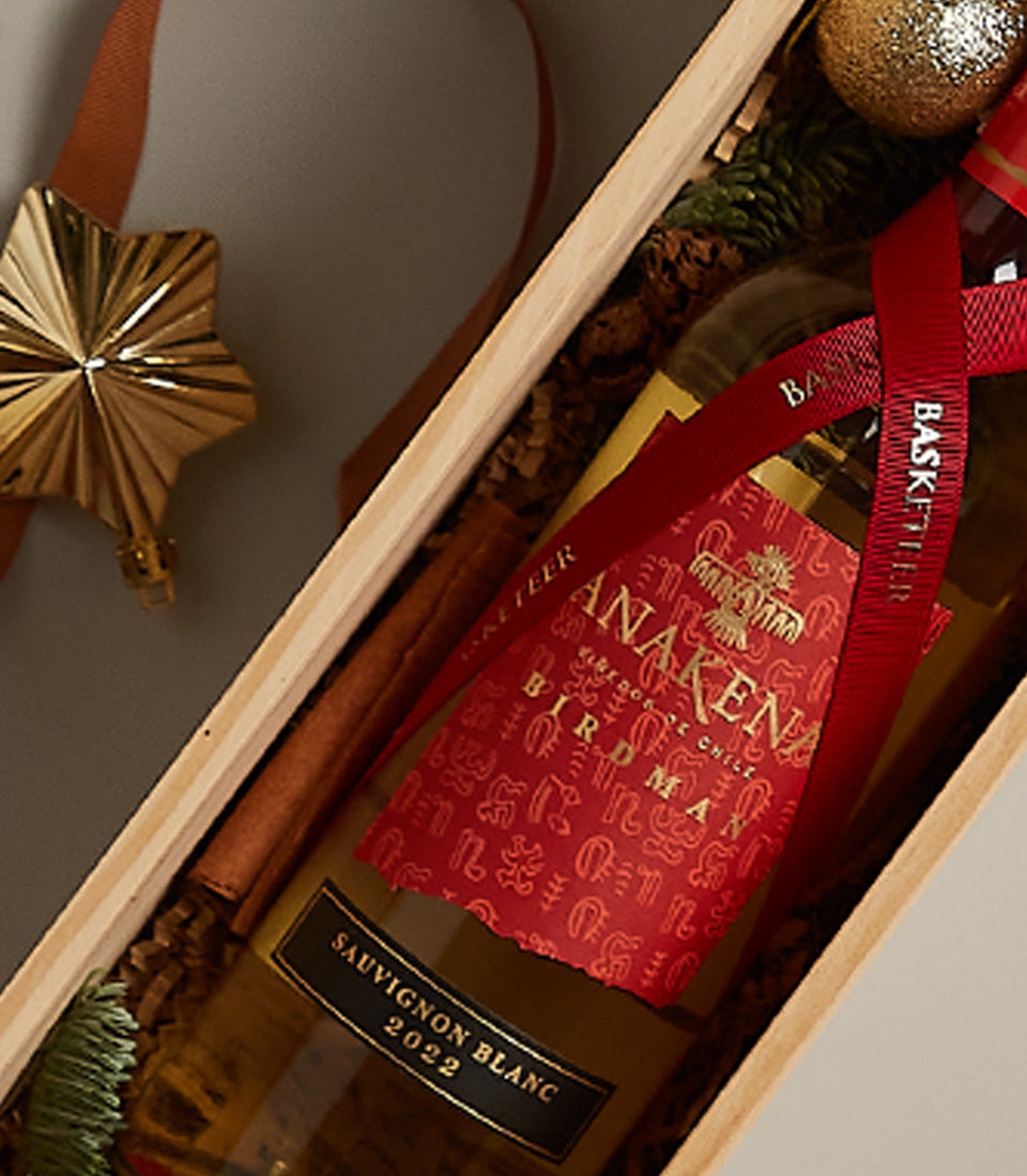 Festive white wine gift box with Sauvignon Blanc, gold star ornament, and holiday greenery