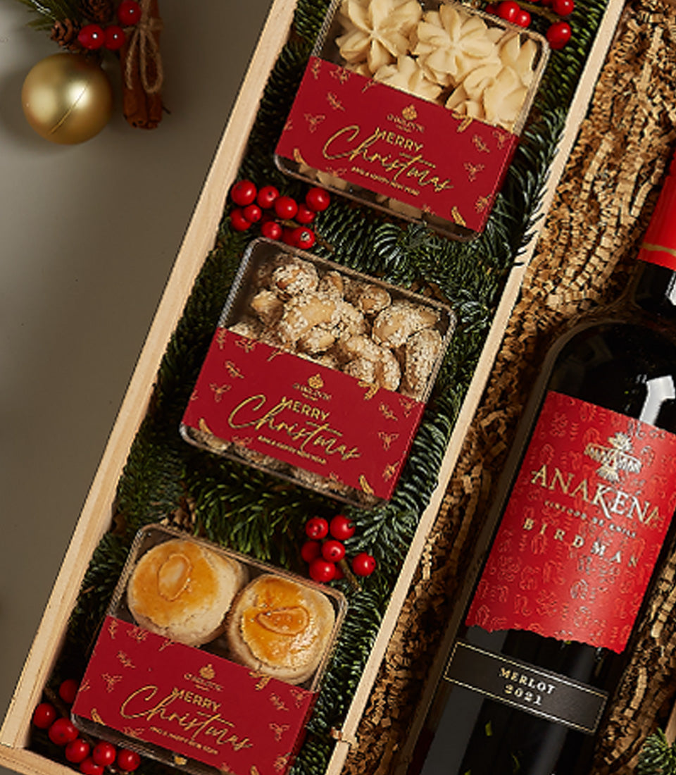 Luxury red wine and festive baked goods Christmas hamper with Merlot, star cookies, and golden pastries