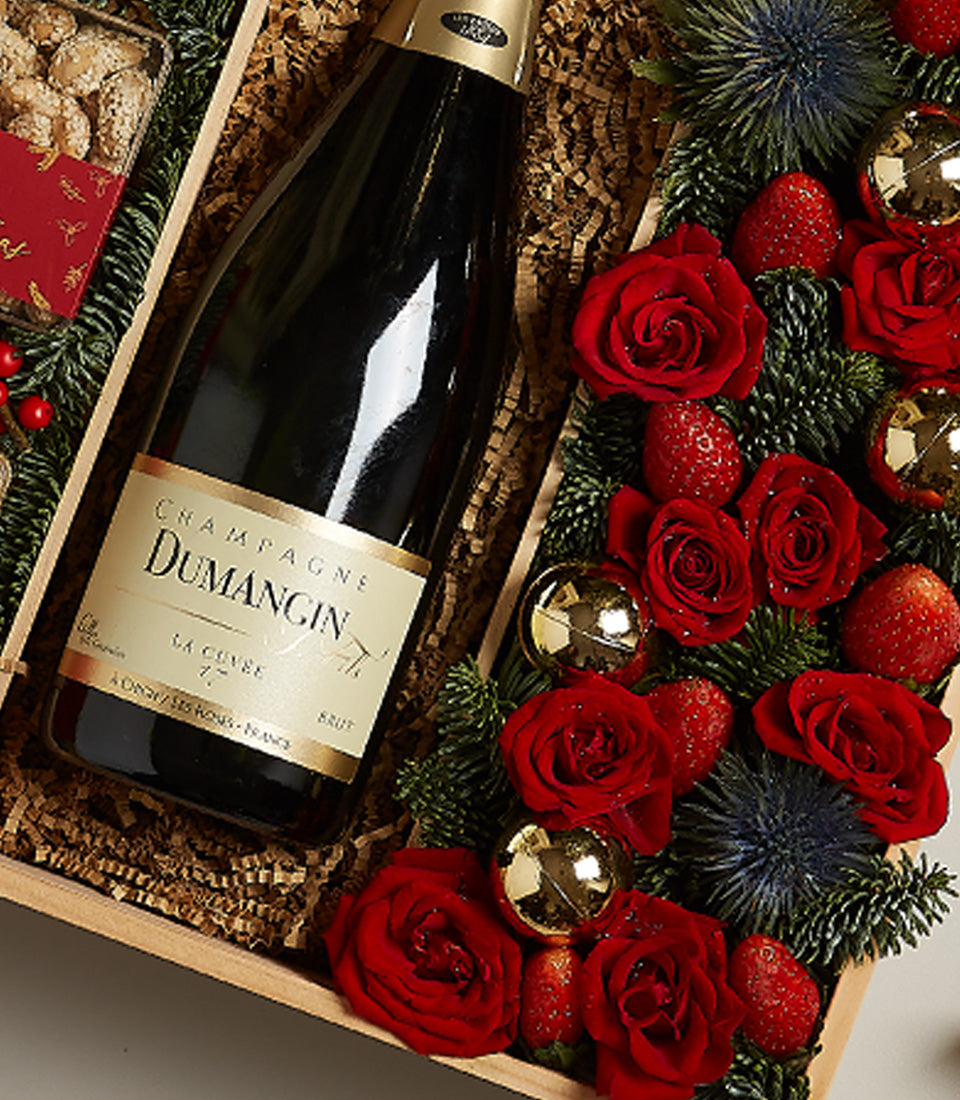 Luxury champagne gift box with Dumangin champagne, fresh red roses, strawberries, and gold ornaments on fir branches