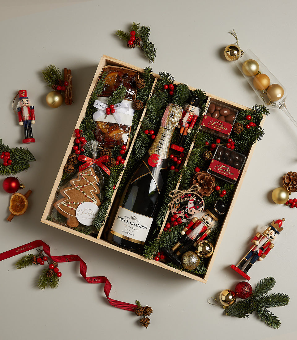 Elegant wooden Christmas gift box with Moët & Chandon champagne, fruit cake, gingerbread cookies, and artisan chocolates