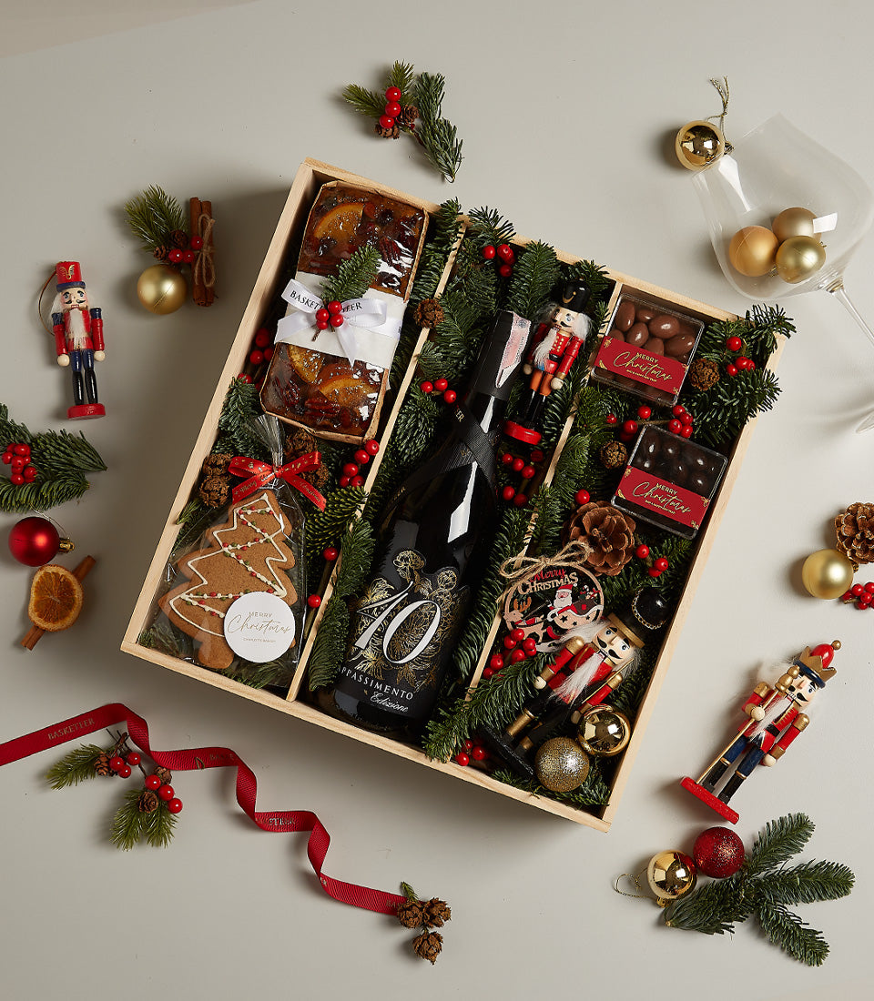 Festive Christmas hamper with Amarone red wine, fruit cake, gingerbread cookie, and artisan chocolates in wooden gift box