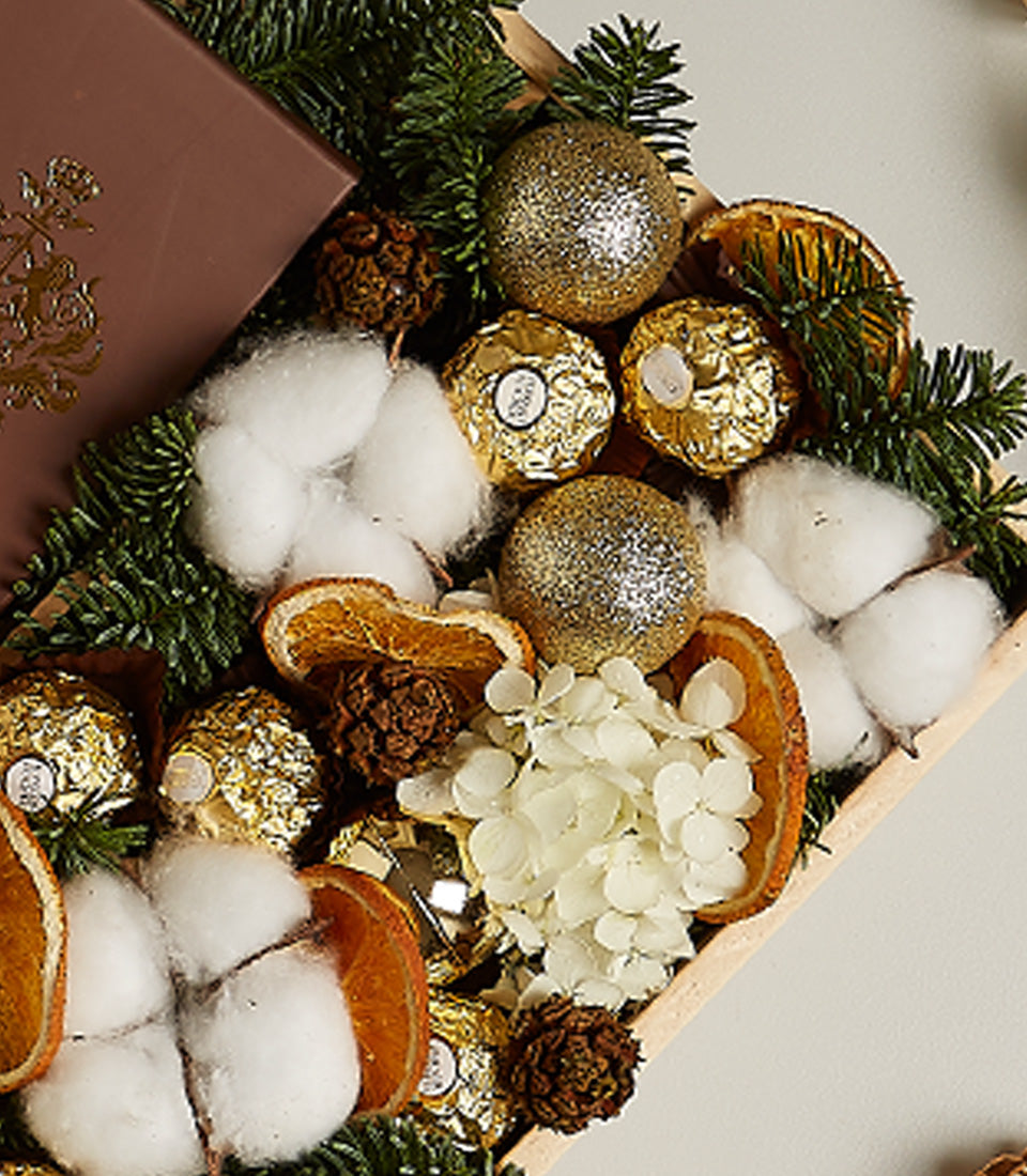 Luxe Christmas gift box with Moët champagne, Ferrero Rocher chocolates, gold ornaments and festive botanicals