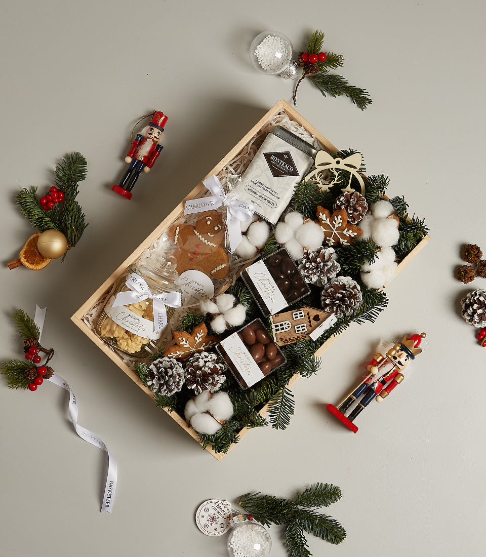 Luxury Winter Wonderland Christmas gift box with gourmet tea, chocolates, gingerbread cookies, and festive pine décor