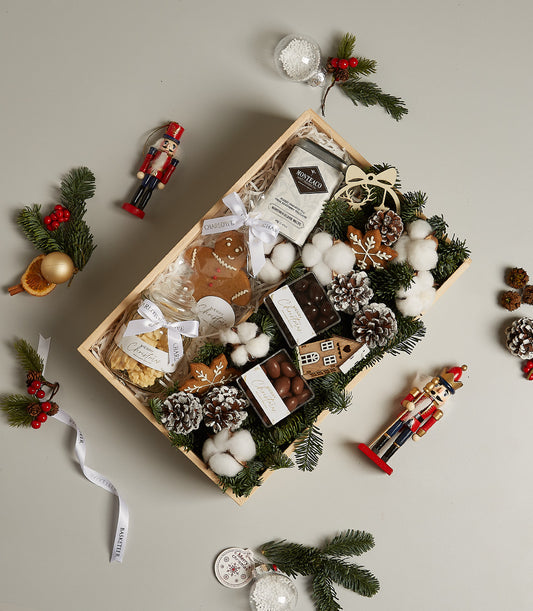 Luxury Winter Wonderland Christmas gift box with gourmet tea, chocolates, gingerbread cookies, and festive pine décor