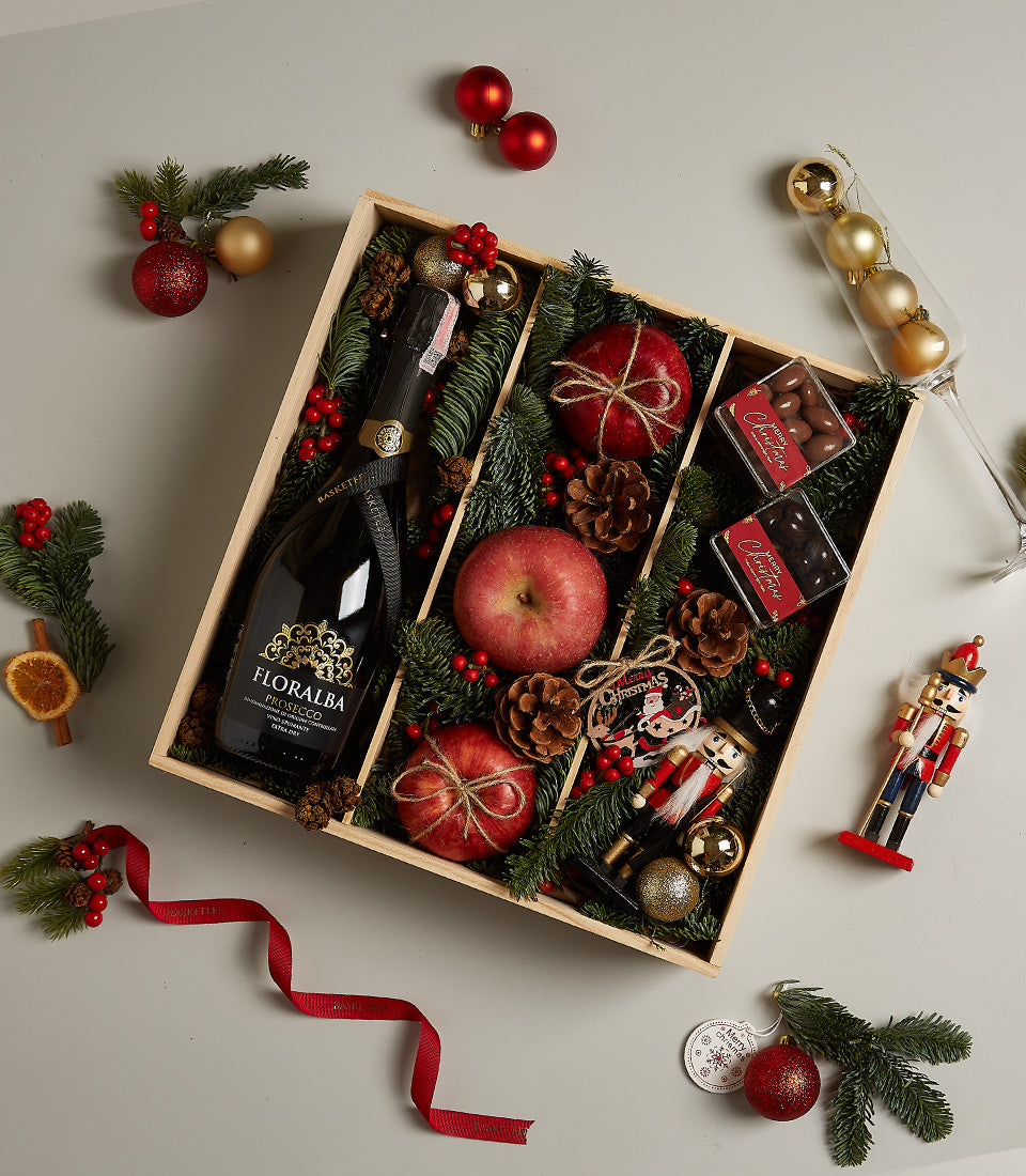 Floralba Prosecco luxury Christmas gift set with champagne flute, dark glass bottle, red apples, chocolates, and festive