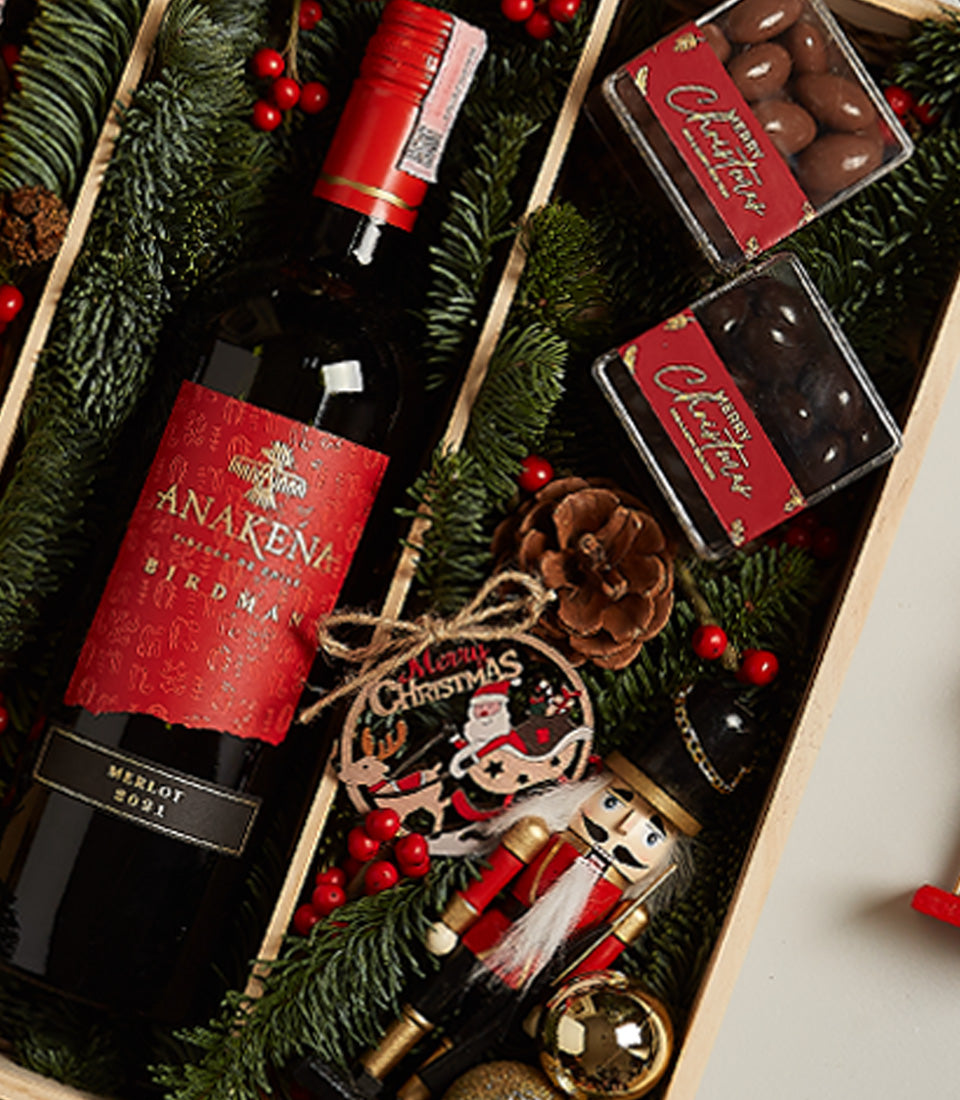 Festive wine gift box with Anakena Merlot, holiday chocolates, and Christmas decorations in wooden presentation box