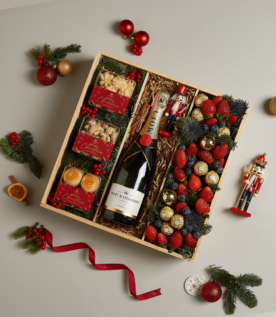 Luxury champagne and festive fruit hamper with Moët & Chandon, fresh berries, chocolates, and baked goods for Christmas