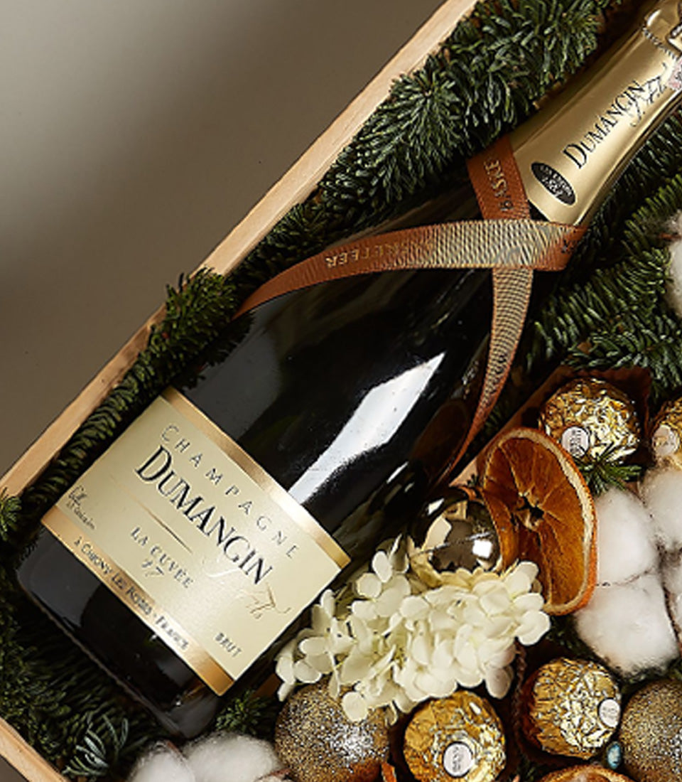 Luxury champagne and Ferrero Rocher chocolates in festive wooden gift box with gold ornaments and evergreen décor