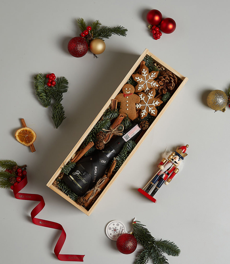 Festive Cheer Prosecco gift box with gingerbread cookies, pine sprigs, and cinnamon for Christmas