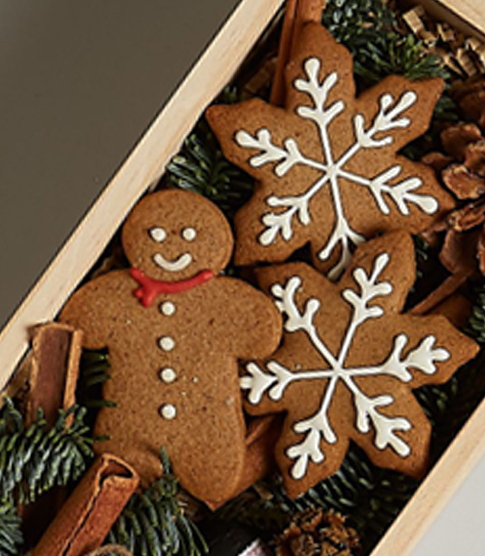 Festive gingerbread and snowflake cookies in wooden box with cinnamon and pinecones for Christmas