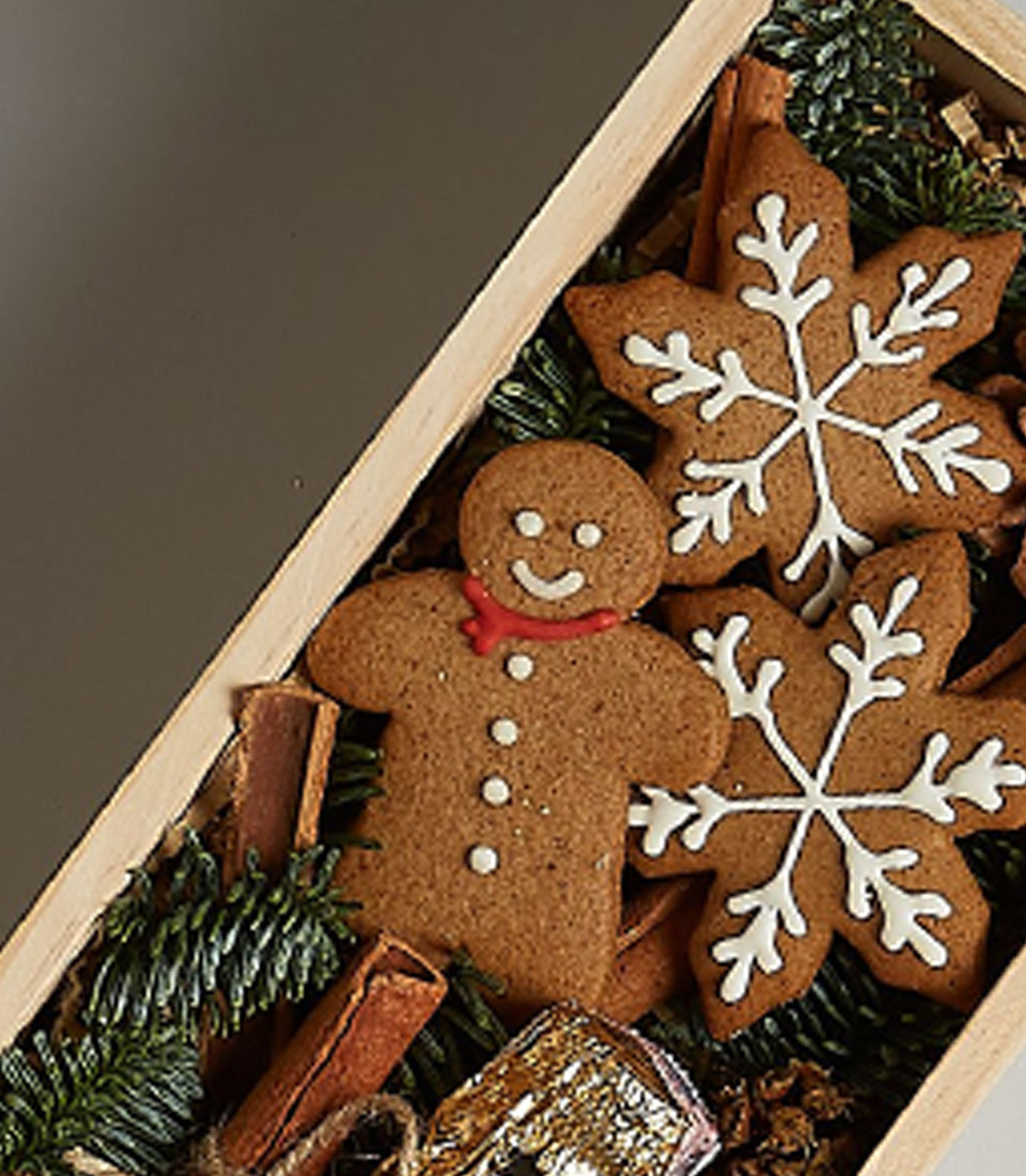 Golden Moët Celebration Box with gingerbread cookies, cinnamon sticks, and festive holiday trimmings in wooden gift box