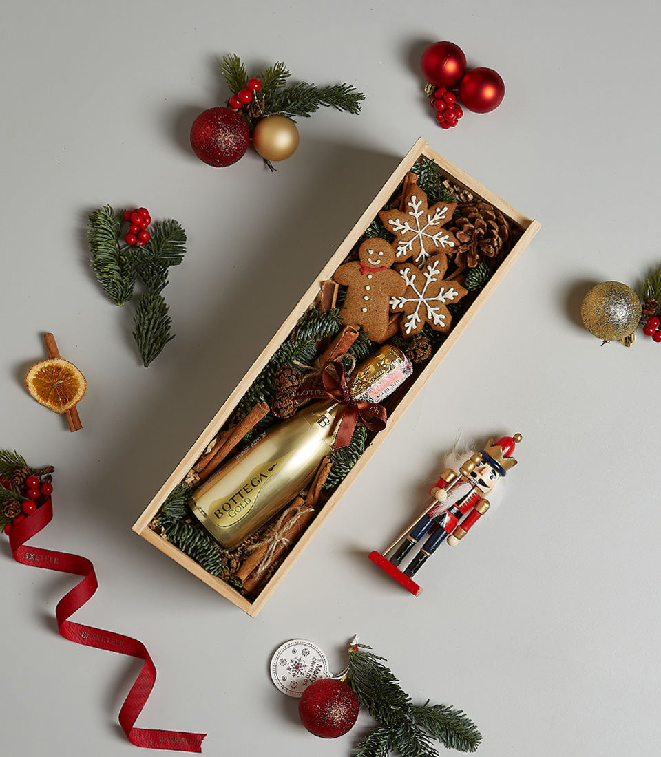 Bottega Gold prosecco gift box with gingerbread cookies, pine, and cinnamon in festive wooden presentation