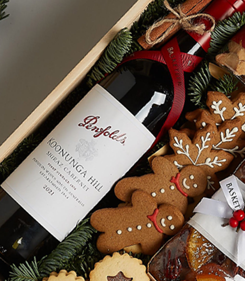 Penfolds Shiraz Cabernet wine with gingerbread cookies, fruitcake, and cinnamon in festive wooden crate