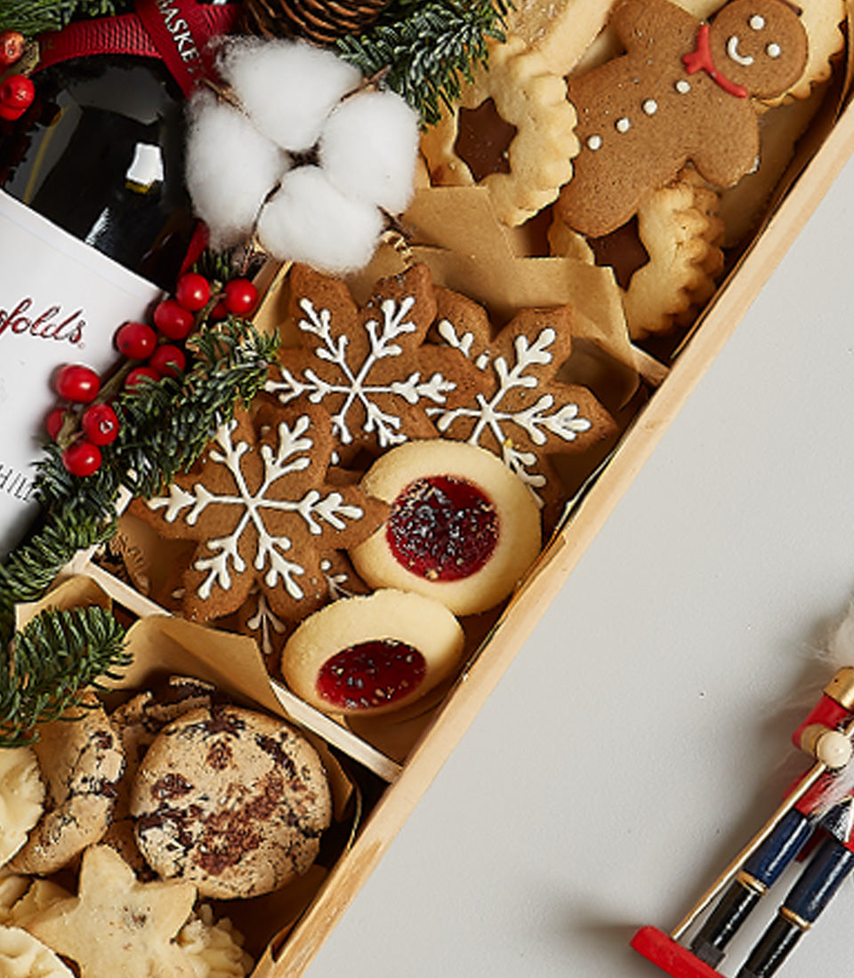 Festive red wine and gourmet cookie gift box with gingerbread, shortbread, and chocolate treats for Christmas