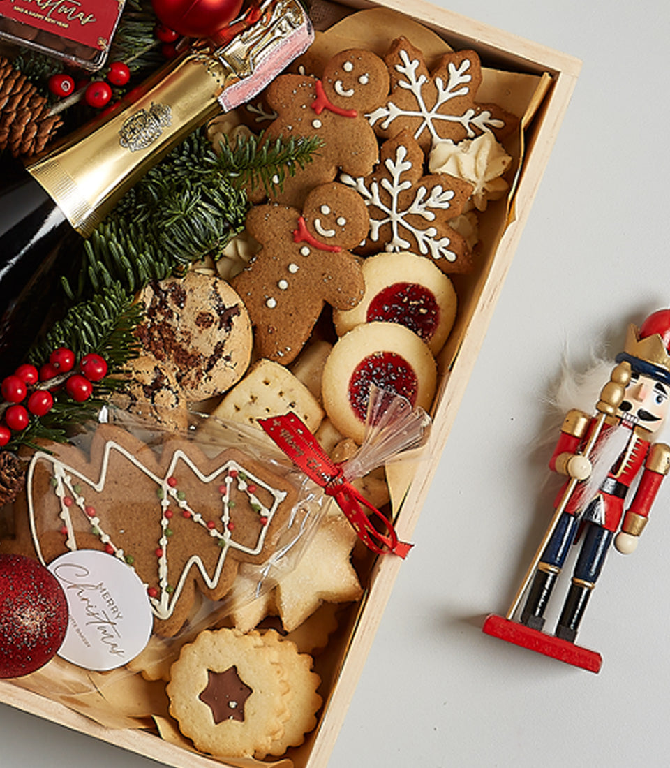 Golden champagne hamper with festive cookies, gingerbread, and sparkling wine in luxury wooden gift box