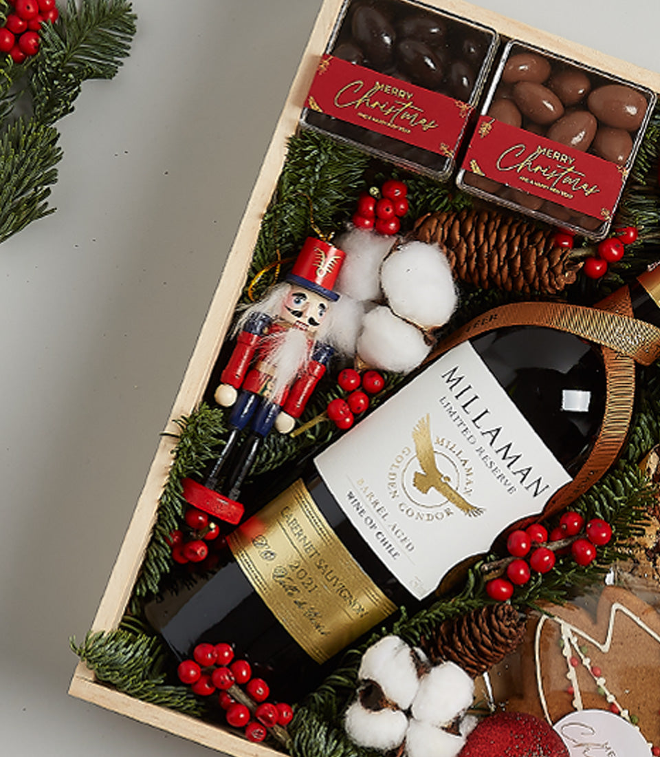 Festive wine hamper with Cabernet Sauvignon, chocolate-covered almonds, gingerbread, and holiday greenery