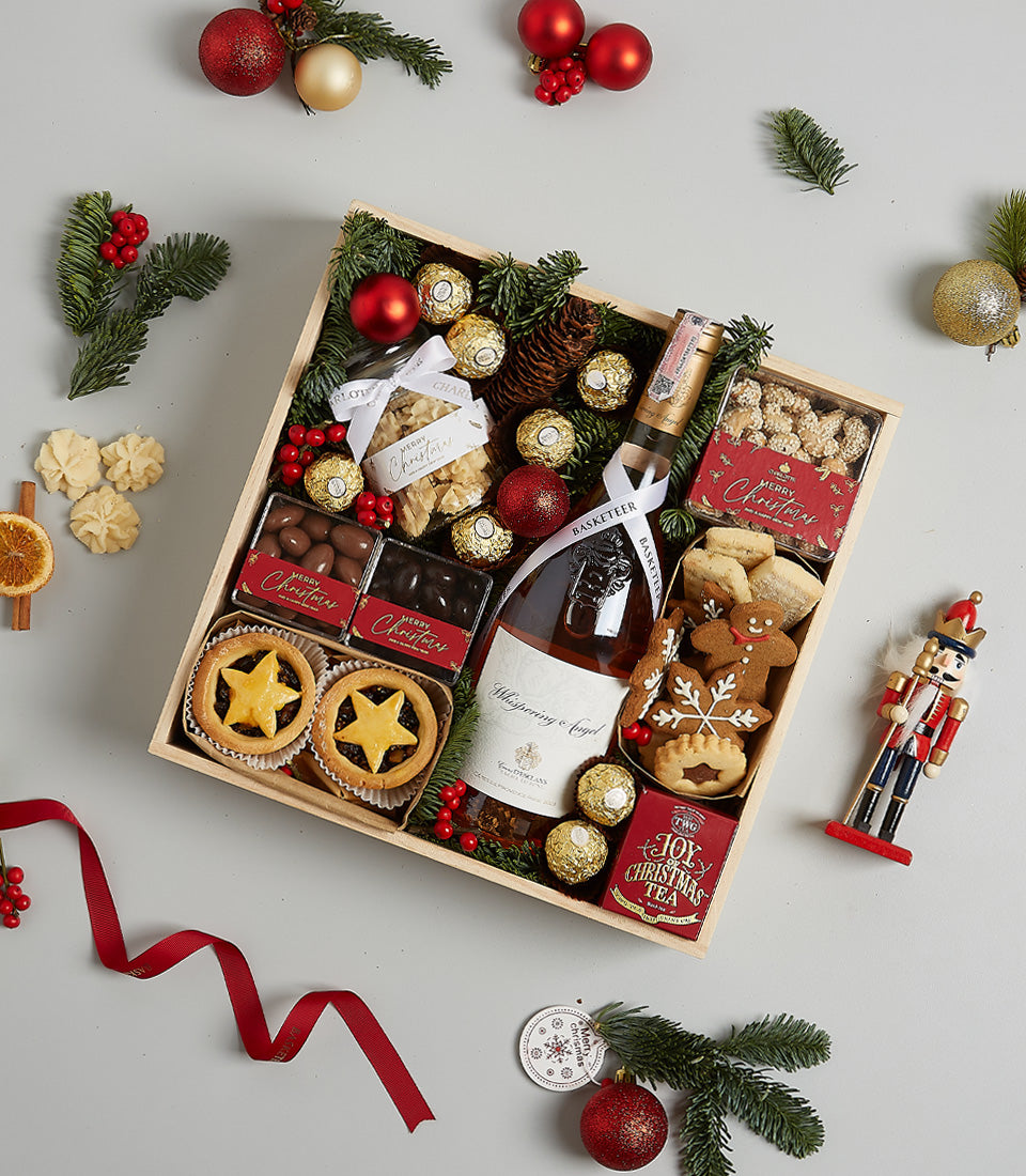 Festive Christmas wine hamper with Whispering Angel rosé, mince pies, gingerbread, chocolates, and holiday tea in wooden
