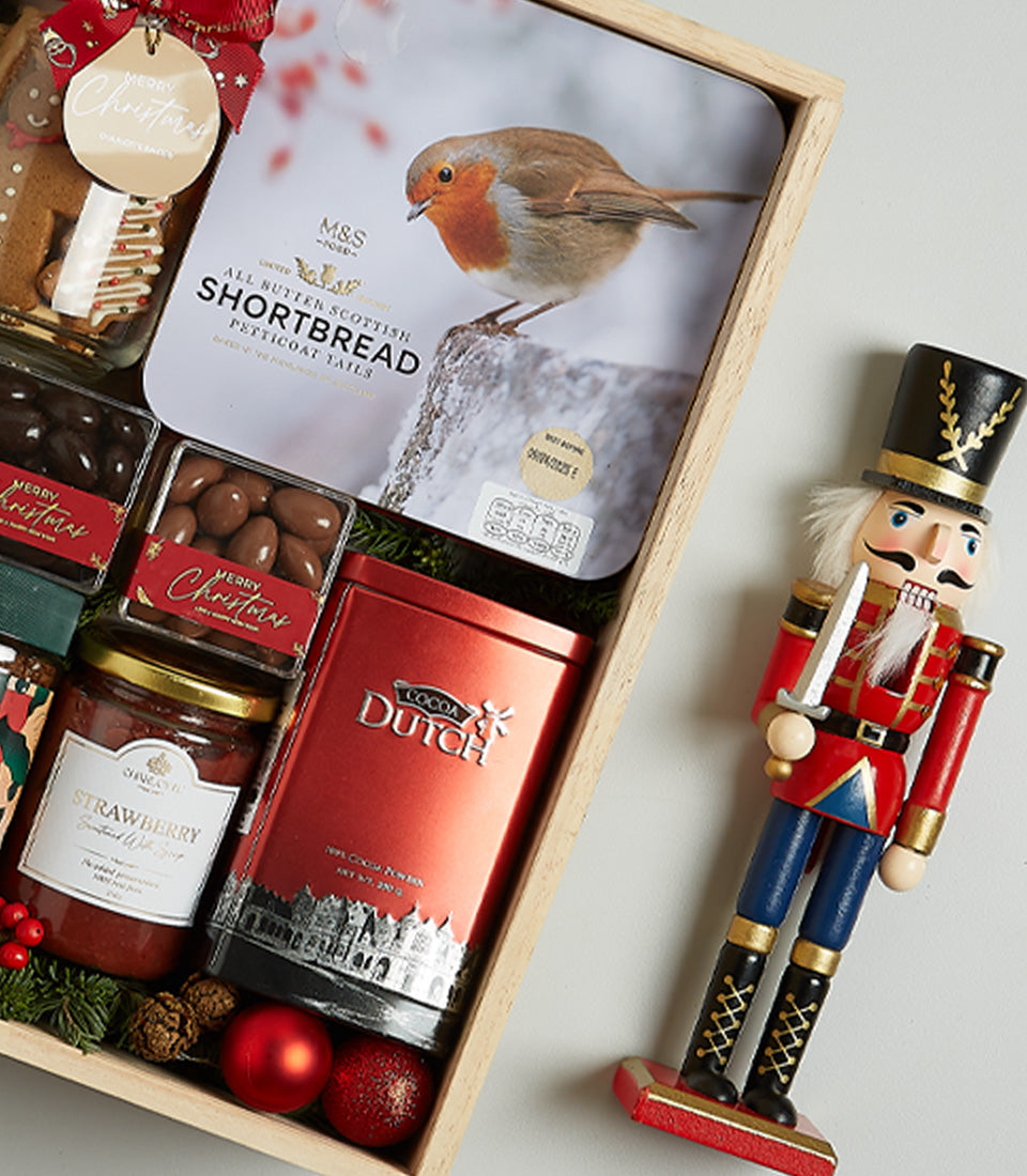 Premium Christmas hamper with Scottish shortbread, strawberry jam, cocoa powder, and festive treats in wooden crate