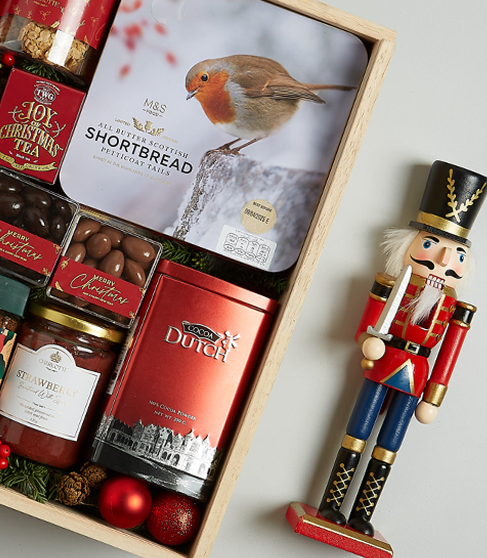 Festive Christmas gourmet hamper with Scottish shortbread, cocoa powder, preserves, and chocolate treats in wooden crate