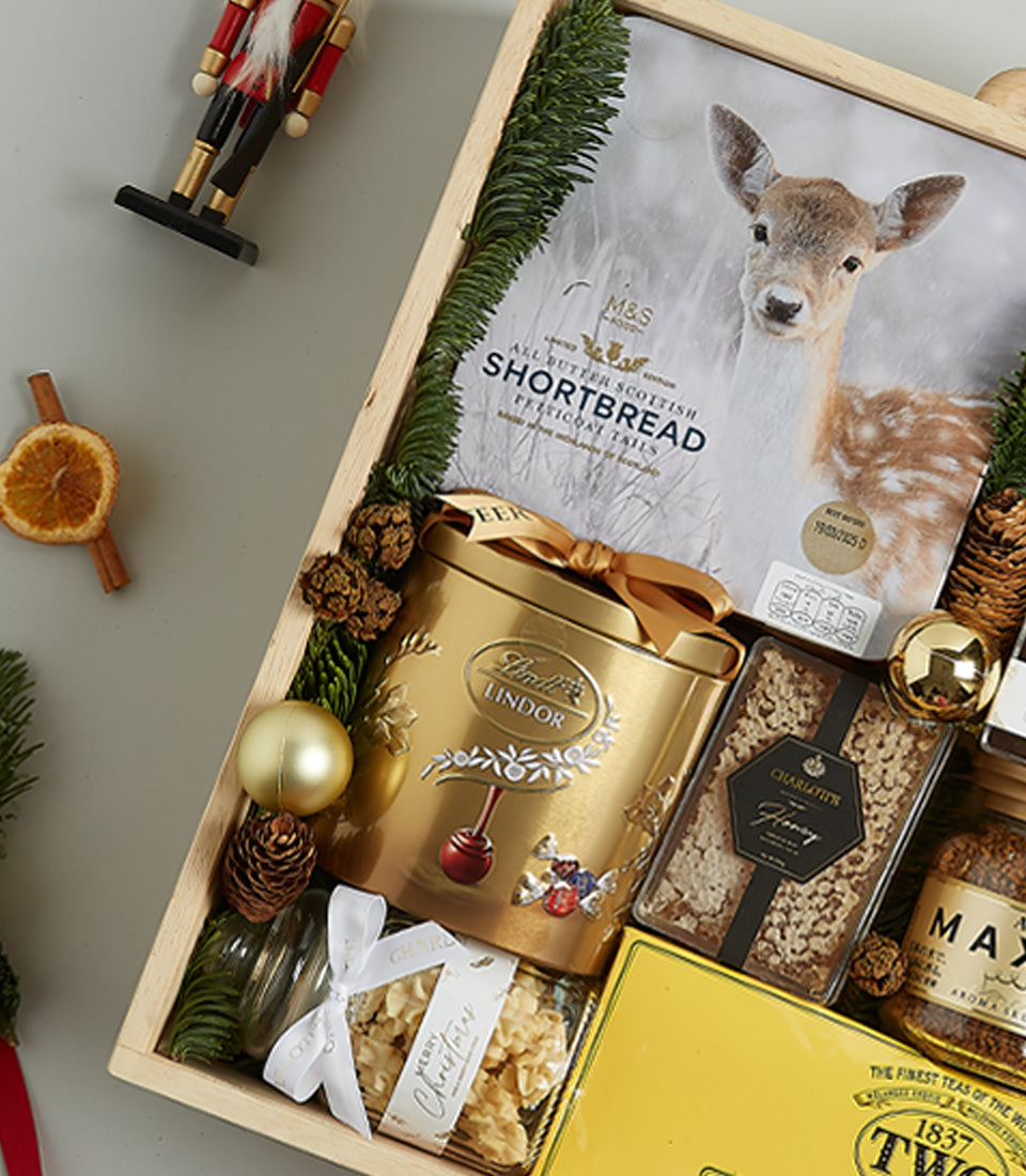 Golden luxury Christmas gift hamper with Scottish shortbread, chocolates, honeycomb, and gourmet treats in wooden crate