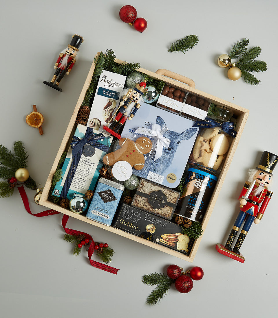 Wooden Christmas gift hamper with Belgian chocolates, gourmet treats, festive ornaments and pine sprigs