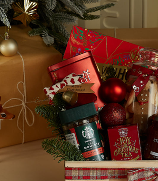 Festive wooden Christmas hamper with gourmet treats, coffee, tea, and holiday decorations