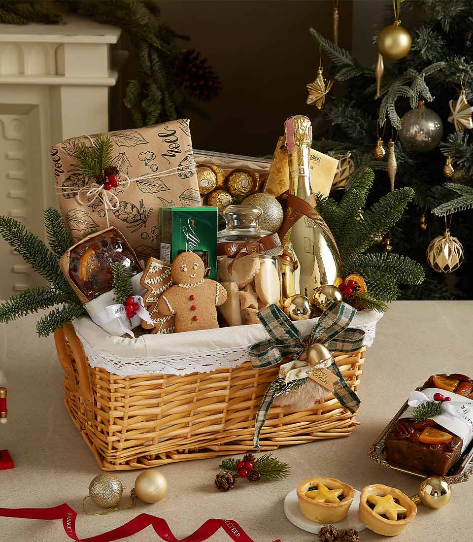 Golden Christmas hamper with Prosecco, gingerbread, chocolates, and festive treats in wicker basket