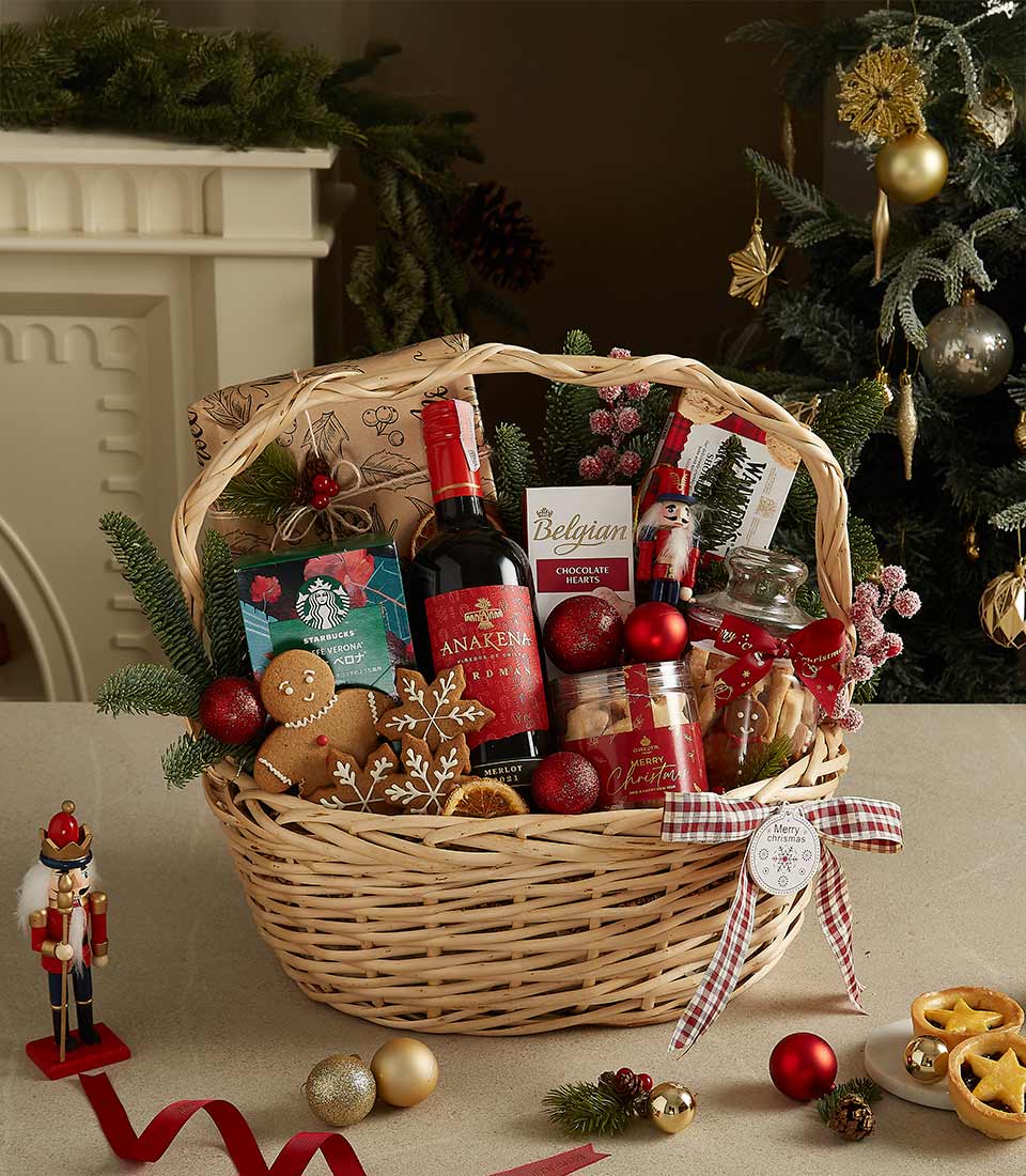 Premium red wine, Belgian chocolate, and gourmet treats in wicker Christmas hamper with festive plaid ribbon