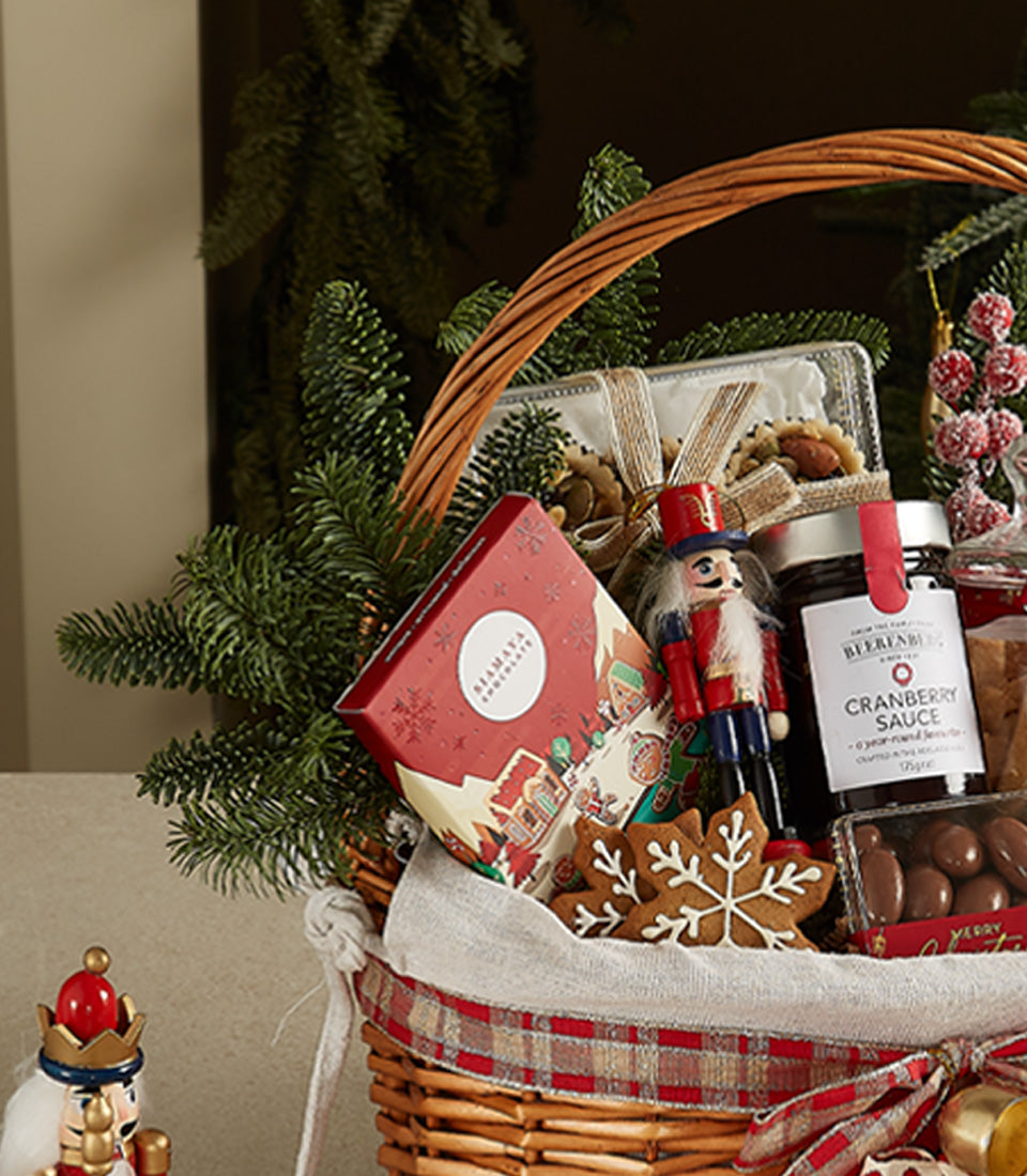 Festive wicker Christmas gift basket with gourmet chocolates, cranberry sauce, and holiday treats