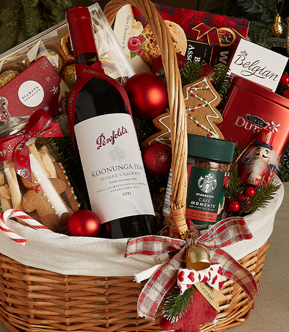 Luxury red wine Christmas gift basket with gourmet chocolates, cookies, and festive wicker presentation